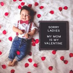 a baby is laying down next to a sign that says sorry ladies my mom is my valentine