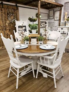 a dining room table with white chairs around it