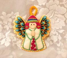 an embroidered angel ornament hanging on a wall