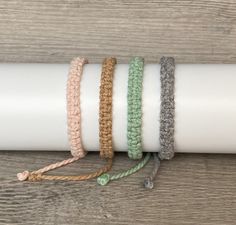 four bracelets on top of each other in different colors and sizes, tied together