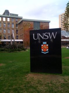 a sign in front of a building with the words unsw on it's side