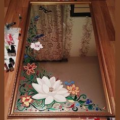 there is a mirror with flowers painted on it