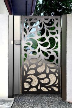 an open metal gate with circular designs on the top and bottom panels, in front of a house