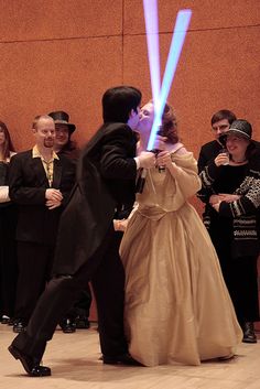 a man and woman dressed up as darth vader and princess leida dancing