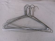 several pieces of metal hangers on a white surface