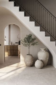 two large vases sitting next to each other in front of a staircase