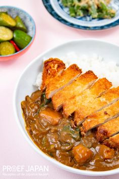 a white plate topped with rice and meat covered in gravy