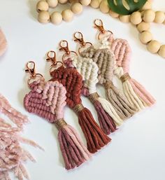 several tasselled heart shaped keychains on a table next to some beads