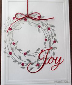 a white card with a red ribbon and a christmas ornament hanging from it