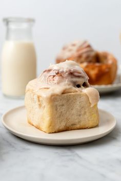 cinnamon rolls on a plate next to a glass of milk