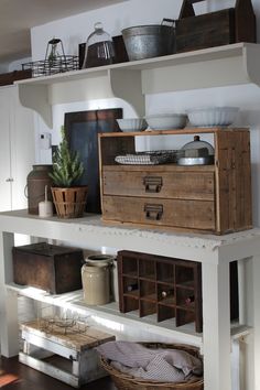 an open shelf in a kitchen filled with pots and pans on top of it