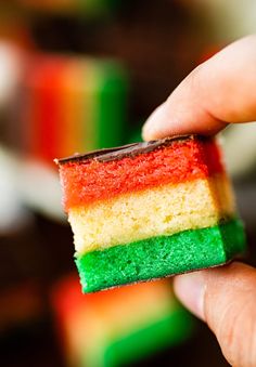 a person holding a piece of cake in their left hand with the rainbow on it