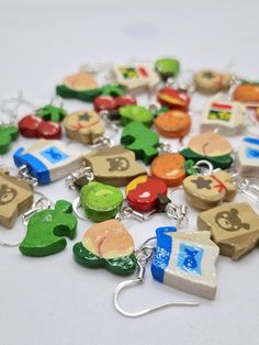 a bunch of different colored wooden charms on a white surface with silver earwires