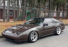 a brown sports car parked on the side of the road