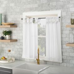 a kitchen with white brick walls and open shelves on the wall, along with a gold faucet