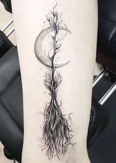 a woman's leg with a tree and moon tattoo design on the left thigh