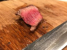 a piece of meat on a cutting board with a knife