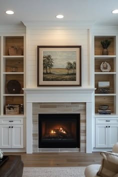 a living room filled with furniture and a fire place under a painting on the wall