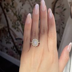 a close up of a person's hand with a diamond ring on her finger