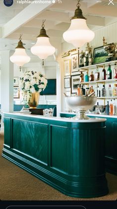 an image of a bar that is in the middle of a room with lights hanging above it