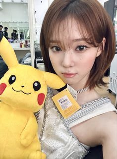 a woman holding a stuffed pikachu toy