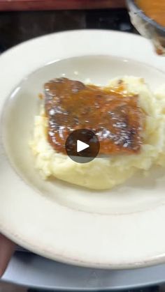 a white plate topped with mashed potatoes and gravy on top of it