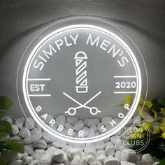 a neon sign that says simply men's barbershop on the side of a wall