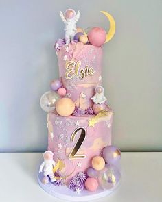 a three tiered cake decorated with balloons and stars