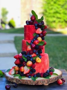 a three tiered cake with fruit on it