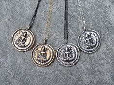 "Thai Buddha Coin Necklace These funky pendants will become your new favorite everyday piece of jewelry! They are modeled after an antique Buddha coin I've had for many years and have cherished. You can customize your necklace by choosing the pendant metal, chain color and length. All pendants are antiqued with a black patina to keep the antique and rustic feel. The original prototype was first carved out of bronze metal clay and then fired in a kiln until only solid metal remained. Each of thes Black Spiritual Jewelry With Antique Finish, Spiritual Black Coin Pendant Jewelry, Black Spiritual Jewelry With Coin Pendant, Black Spiritual Necklace With Coin Pendant, Spiritual Necklace With Antique Finish Round Pendant, Spiritual Necklaces With Antique Finish Round Pendant, Spiritual Antique Finish Round Pendant Necklace, Spiritual Round Pendant Necklace With Antique Finish, Symbolic Pendant Necklaces With Antique Finish