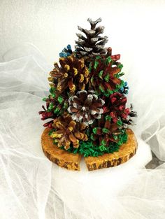 a pine cone is sitting on top of a piece of wood with other decorations around it