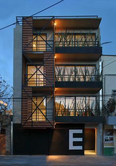 an apartment building with balconies lit up at night