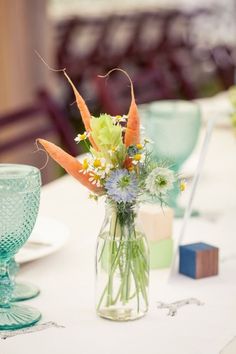 a vase filled with flowers sitting on top of a white tablecloth covered dining room table