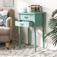 a blue table with two drawers and a chair next to it in a living room