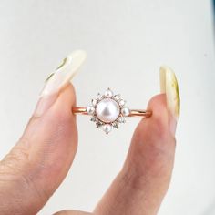 Product Description: Introducing Elara, a beautifully handcrafted ring that exudes elegance and timeless charm. At its center lies a 5mm Akoya pearl, radiating a soft, natural luster. Surrounding the pearl are smaller pearls and sparkling moissanite stones, delicately arranged to create a flower-inspired design. For those looking for an extra touch of luxury, the moissanite stones can be replaced with diamonds upon request. The Elara ring’s sweet, fresh aesthetic perfectly blends modern fashion with classic sophistication, making it ideal for daily wear, a memorable anniversary gift, or a meaningful promise ring. Design Concept: The Elara ring was crafted with nature’s beauty and elegance in mind, drawing inspiration from the delicate bloom of flowers. The soft glow of the Akoya pearl, pai Wedding Pearl Drop Ring With Diamond, Elegant Pearl Ring With Halo For Wedding, Pearl Promise Ring With Halo Setting, Elegant Pearl Promise Ring With Halo Setting, 14k Gold Pearl Ring With Center Stone For Wedding, Diamond Halo Pearl Ring For Wedding, Wedding Pearl Ring With Diamond Halo, Delicate Pearl Ring With Diamond, Diamond Pearl Ring With Halo For Wedding