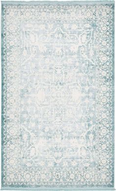 a light blue and white rug with an ornate design on the bottom, in front of a