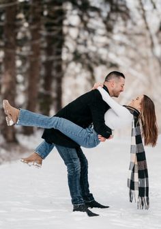 Playful winter engagement photo of a couple in a snowy forest, with the man lifting the woman as they smile at each other Winter Couple Photoshoot, Winter Couples Photoshoot, Poses Winter, Christmas Engagement Photos, Winter Engagement Shoot, Winter Pics, Boat Pics, Loving Energy, Photography Trends