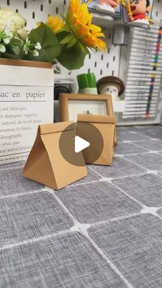 an open cardboard box sitting on top of a table next to some pictures and flowers