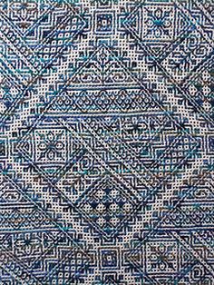 a blue and white rug with an intricate design on the front, in different colors