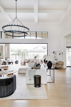 a living room filled with lots of furniture and a chandelier hanging from the ceiling