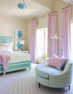 a bedroom decorated in pastel colors with pink and blue accents