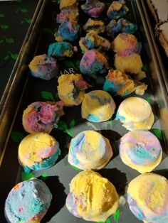 some cupcakes with different colored frosting are on a tray next to each other