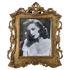 an old photo of a woman in a gold frame