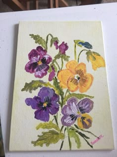 the painting is being displayed on the easel, with flowers painted in different colors