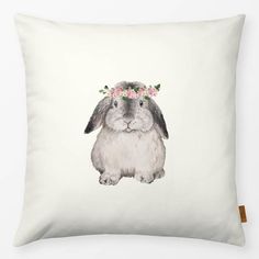 a white pillow with a bunny wearing a flower crown on it's head and sitting in front of a white background