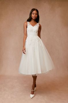 a woman in a white dress standing on a beige background