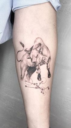 a tattoo on the leg of a man with a bull and crossbone in it