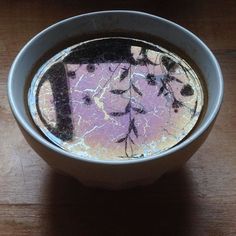 a bowl filled with water sitting on top of a wooden table