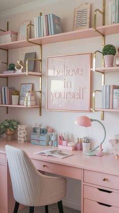 a pink desk topped with lots of shelves filled with books and office supplies next to a white chair