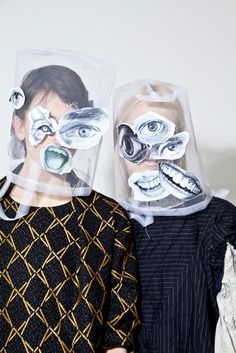 two people with plastic covering their faces